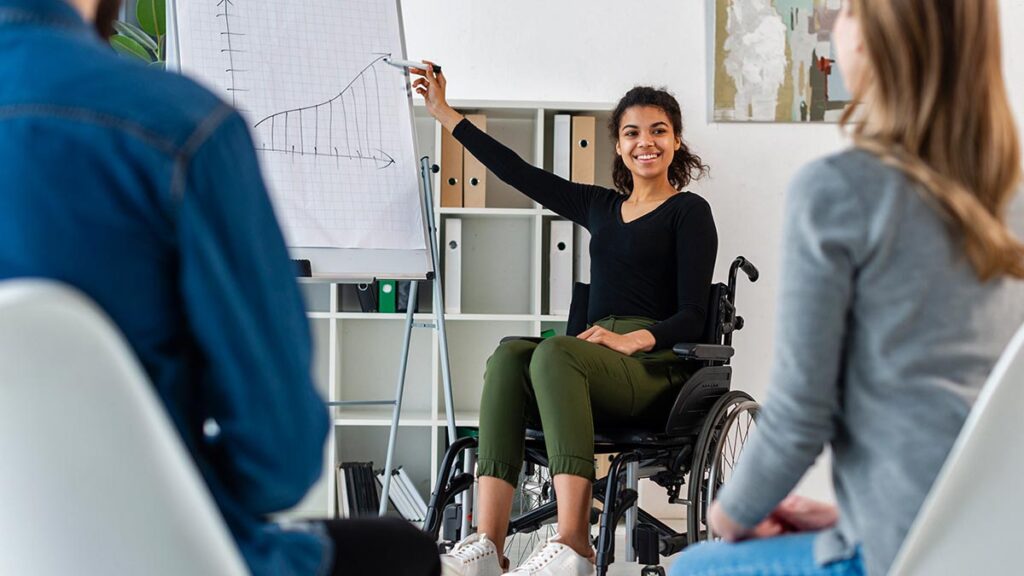 persona-con-discapacidad-trabajando Mujer en silla de ruedas presentando proyecto